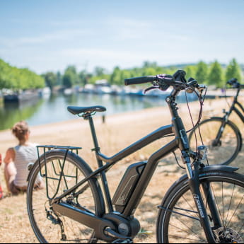 Vélo à assistance électrique Moustache bikes Couple assis au bord de l&#039;eau